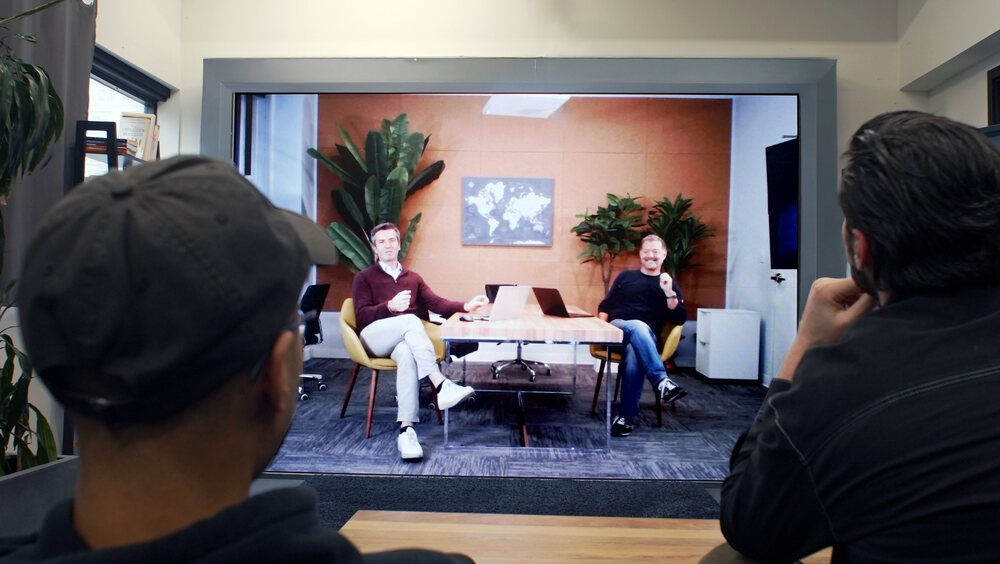 Two colleagues in conversation across a life-size Noro wall